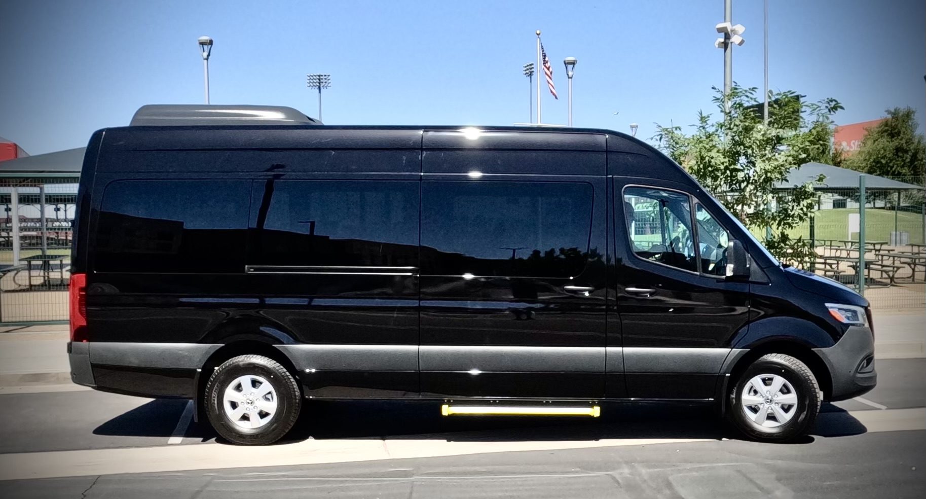 DCIM100GOPROGOPR1025.JPG A black passenger van parked in a sunny lot.