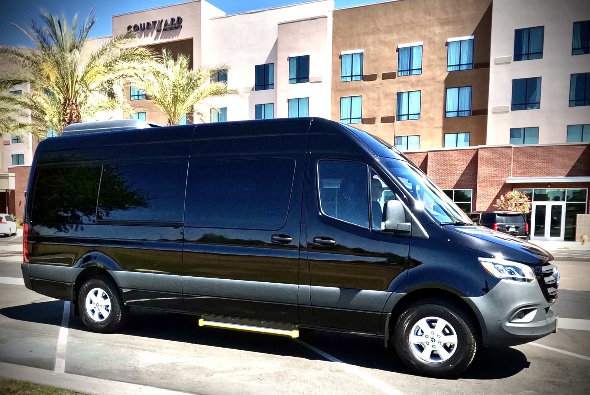 DCIM100GOPROGOPR1012.JPG Black passenger van parked in front of a hotel building.